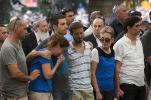 Family of 2nd Lt. Hadar Goldin mourning over his grave during his funeral at the military cemetery in Kfar Saba on August 3, 2014, The IDF spokesman on Sunday morning announced the death of IDF officer Lt. Hadar Goldin, who fell in battle in the Gaza Strip on Friday. on Saturday, the Chief Rabbi of the IDF, Brigadier Gen. Rafi Peretz, declared Goldin dead. The decision was made according to the findings of a special board, headed by Peretz, who considered medical, halachic and other relevant considerations. Photo by Yonatan Sindel/Flash90 *** Local Caption *** ??? ?????? ?? ???? ????? ???? ?????? ???? ??? ????? ?????? ??? ???? ??? ????