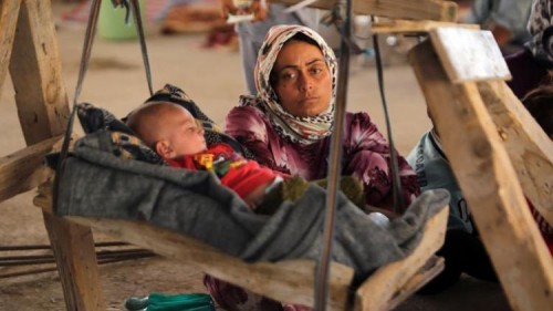 crédits/photos : AFP Une femme irakienne Yazidi, qui a fui son domicile lorsque des militants de l'État islamique ont attaqué la ville de Sinjar, avec son bébé à l'intérieur d'un bâtiment en cours de construction à la périphérie de la ville kurde de Dohouk, le 16 Août 2014