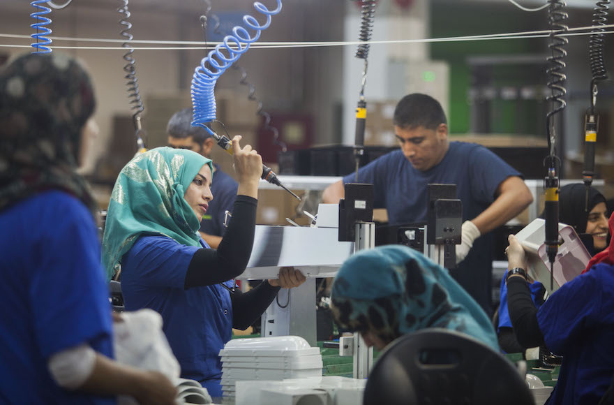 Employees work at the new SodaStream factory built deep in Israel's Negev Desert next to the city of Rahat, Israel, that will replace the West Bank facility when it shuts down in two weeks time, Wednesday, Sept. 2, 2015. The chief executive of SodaStream, Daniel Birnbaum announced the shuttering of its West Bank factory in the face of international boycott calls, accusing company critics of anti-Semitism, but the Boycott, Divestment and Sanctions (BDS) international boycott campaign declared a victory and said its pressure was behind the decision. (Photo/Dan Balilty)