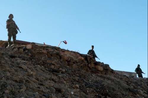 Russian and Syrian soldiers stand guard a hill in Rastan, central Homs province, on August 15, 2018. - Syria's government forces took back the rebel towns of Talbisseh, Rastan, and Al-Houla in May 2018. (Photo by Andrei BORODULIN / AFP)