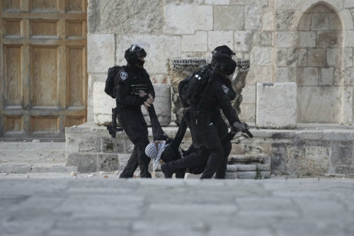 Israeli police carry a Palestinian protester during clashes at the Al Aqsa Mosque compound in Jerusalem's Old City, Friday, April 22, 2022. (AP Photo/Mahmoud Illean)
