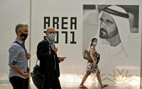 (FILES) In this file photo taken on October 27, 2020, Members of Israeli high-tech delegation walk past a poster of Dubai's ruler Sheikh Mohammed bin Rashid al-Maktoum during a meeting with Emirati counterparts at the headquarters of the Government Accelerators in Dubai. - Before normalisation, there had been discreet links between UAE and Israel's flourishing high-tech sector. But after the deal brokered by President Donald Trump, who is seeking re-election, those links have come to the surface and are poised to expand. (Photo by Karim SAHIB / AFP)