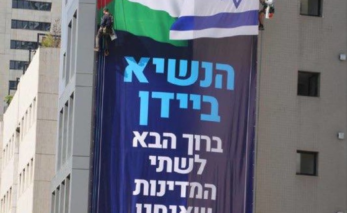 Tel-Aviv : un mouvement politique accroche une affiche avec le drapeau israélien et palestinien côte à côte avant l’arrivée du président Biden