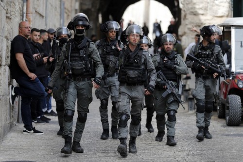 Israeli border police patrol in front of the Lion's Gate in Jerusalem's Old City, as Palestinians wait to be allowed to enter the al-Aqsa mosque compound, on April 17, 2022. (Photo by Ahmad GHARABLI / AFP)