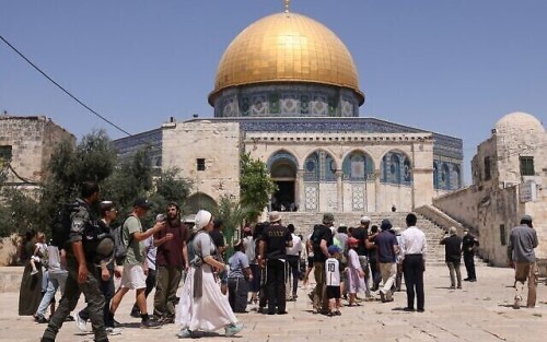 Members of the Israeli security forces stand guard, as a group of Orthodox Jews enter the al-Aqsa mosque compound in Jerusalem, during the annual Tisha B'Av (Ninth of Av) fasting and memorial day, commemorating the destruction of ancient Jewish temples some 2000 years ago, on July 18, 2021. (Photo by AHMAD GHARABLI / AFP)