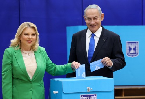 Likud chairman Benjamin Netanyahu (R) and his wife Sara cast their ballot at a polling station in Jerusalem in the country's fifth election in less than four years on November 1, 2022. - Israelis began voting in their latest legislative election today, with veteran leader Benjamin Netanyahu campaigning for a comeback alongside far-right allies. (Photo by RONALDO SCHEMIDT / AFP)