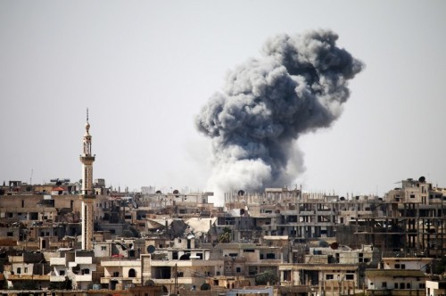 Smoke billows in the distance following reported air strikes on the southern Syrian city of Daraa on February 22, 2017. / AFP PHOTO / MOHAMAD ABAZEED