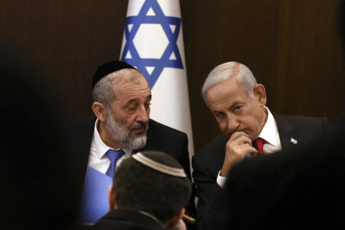 (FILES) In this file photo taken on January 08, 2023 Israel's Prime Minister Benjamin Netanyahu (R) sits next to Interior and Health Minister Aryeh Deri during a weekly cabinet meeting at the Prime Minister's office in Jerusalem, on January 8, 2023. Israel's top court on January 18 said that Benjamin Netanyahu must relieve Deri, a senior member of his newly formed government, from his ministerial duties in light of a recent tax evasion conviction. Prime Minister Netanyahu returned to power last month at the head of a coalition with extreme-right and ultra-Orthodox Jewish parties following Israel's November 1 election. (Photo by RONEN ZVULUN / POOL / AFP)