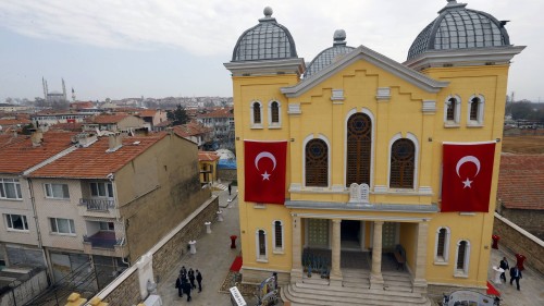 Turkish flags are seen on the facade of the restored Great Synagogue before a re-opening ceremony in Edirne, western Turkey March 26, 2015. A five-year, $2.5 million government project has restored the Great Synagogue in the border city of Edirne, the first temple to open in Turkey in two generations. The opening is part of a relaxation of curbs on religious minorities during President Tayyip Erdogan's 12 years in power. The Ottoman-era Suleymaniye mosque is seen in the background (top L).  REUTERS/Murad Sezer
