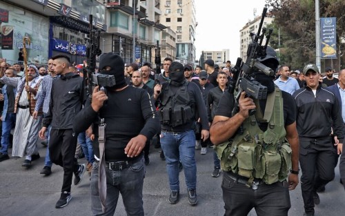 Palestinian militants attend the funeral of those killed in an overnight Israeli raid, in the occupied West Bank city of Nablus on October 25, 2022. - Six Palestinians were killed and nearly 20 others injured in sweeping raids by Israeli forces in the occupied West Bank, the Palestinian Health Ministry said. Israeli Prime Minister Yair Lapid said that Wadih Al Houh, a militant leader of a new coalition of Palestinian fighters dubbed "The Lions' Den", had been among those killed in the northern West Bank city of Nablus. (Photo by RONALDO SCHEMIDT / AFP)