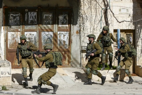 Israeli security forces point their rifles during clashes with Palestinians following a raid in the Bethlehem area this morning in search of a suspect wanted for a car-ramming attack earlier in Jerusalem that left several people injured, on February 6, 2020. - A manhunt was underway for the driver in the car-ramming, who fled the scene in central west Jerusalem after the attack, which took place shortly before 2:00 am (2400 GMT). The attacker struck on the street where the soldiers had been marching, the army said. (Photo by Musa Al SHAER / AFP)