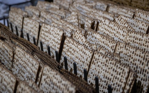 Workers prepare matza, traditional unleavened bread eaten during the 8-day Jewish holiday of Passover, in "Yehuda Matzos" Plant in Jerusalem March 16, 2021. Photo by Yonatan Sindel/Flash90 *** Local Caption *** מצות מצה פסח ירושלים מאפייה מצות יהודה עובד עובדים