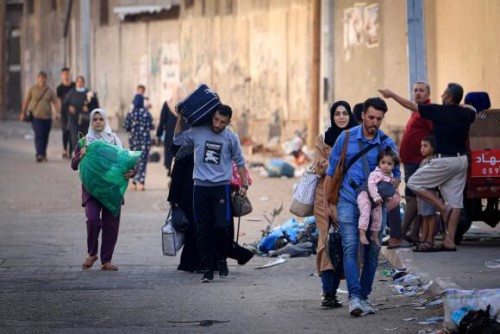 Palestinians with their belongings flee to safer areas in Gaza City after Israeli air strikes, on October 13, 2023. Israel has called for the immediate relocation of 1.1 million people in Gaza amid its massive bombardment in retaliation for Hamas's attacks, with the United Nations warning of "devastating" consequences. (Photo by MAHMUD HAMS / AFP)