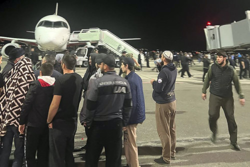 People in the crowd walk shouting antisemitic slogans at an airfield of the airport in Makhachkala, Russia, Monday, Oct. 30, 2023. Russian news agencies and social media say hundreds of people have stormed into the main airport in the Dagestan region and onto the landing field to protest the arrival of an airliner coming from Tel Aviv, Israel. (AP Photo)