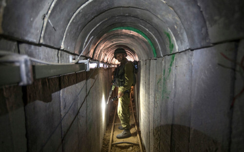 An Israeli army officer walks on July 25, 2014 during an army-organised tour in a tunnel said to be used by Palestinian militants from the Gaza Strip for cross-border attacks. Israel launched its military offensive aiming at destroying tunnels used by Gaza militants. AFP PHOTO / POOL / JACK GUEZ (Photo by JACK GUEZ / POOL / AFP)