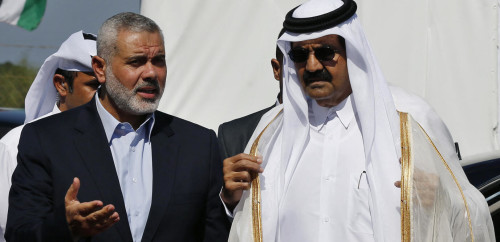 Hamas prime minister Ismail Haniya (L) and the Emir of Qatar Sheikh Hamad bin Khalifa al-Thani arrive to a cornerstone laying ceremony for Hamad, a new residential neighbourhood in Khan Yunis in the southern Gaza Strip on October 23, 2012. Qatar's emir was warmly welcomed on a landmark tour of the Gaza Strip in the first such visit by a head of state since the Islamist Hamas movement took over in 2007. AFP PHOTO/POOL/MOHAMMED SALEM (Photo by Mohammed Salem / POOL / AFP)