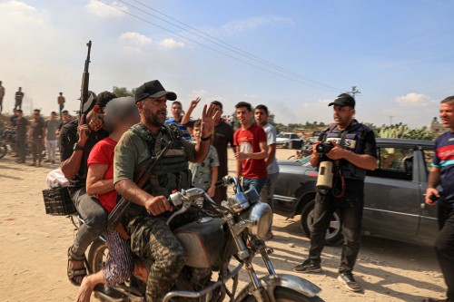 Palestinian militants transport a reportedly captured Israeli woman by motorcycle, in Khan Yunis in the southern Gaza Strip, on October 7, 2023. Palestinian militants had begun a "war" against Israel which they infiltrated by air, sea and land from the blockaded Gaza Strip on October 7, Israeli officials said, a major escalation in the Israeli-Palestinian conflict. (Photo by AFP) (Photo by -/AFP via Getty Images) PALESTINIAN-ISRAEL-GAZA-CONFLICT