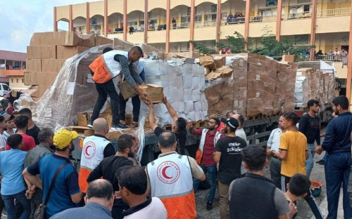 Members of the Palestine Red Crescent Society distribute aid to people in Khan Younis, in the southern Gaza Strip, in this handout picture released on October 25, 2023.  Palestine Red Crescent Society/Handout via REUTERS    THIS IMAGE HAS BEEN SUPPLIED BY A THIRD PARTY. MANDATORY CREDIT. NO RESALES. NO ARCHIVES. BEST QUALITY AVAILABLE