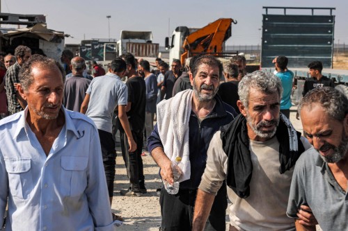 Palestinian workers, who were stranded in Israel since the October 7 attacks, cross back into the Gaza Strip at the Kerem Shalom commercial border crossing with Israel in the south of the Palestinian enclave on November 3, 2023. (Photo by Mohammed ABED / AFP)