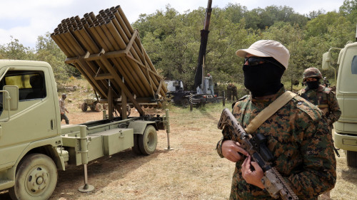 Lebanese Hezbollah fighters stand near a multiple rocket launcher during a press tour in the southern Lebanese village of Aaramta, on May 21, 2023, ahead of the anniversary of the Israeli withdrawal from Lebanon. (Photo by ANWAR AMRO / AFP) (Photo by ANWAR AMRO/AFP via Getty Images)