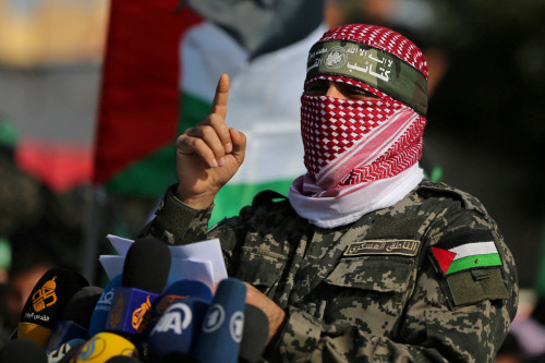 FILE PHOTO: Abu Ubaida, the spokesman of the Izz el-Deen al-Qassam Brigades, gestures as he speaks during an anti-Israel military show in the southern Gaza Strip November 11, 2019. REUTERS/Ibraheem Abu Mustafa/File Photo