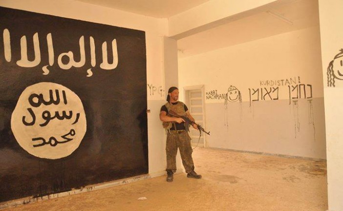 Un juif du PKK tague Na Na’hman Méouman près d’un drapeau de l’ISIS