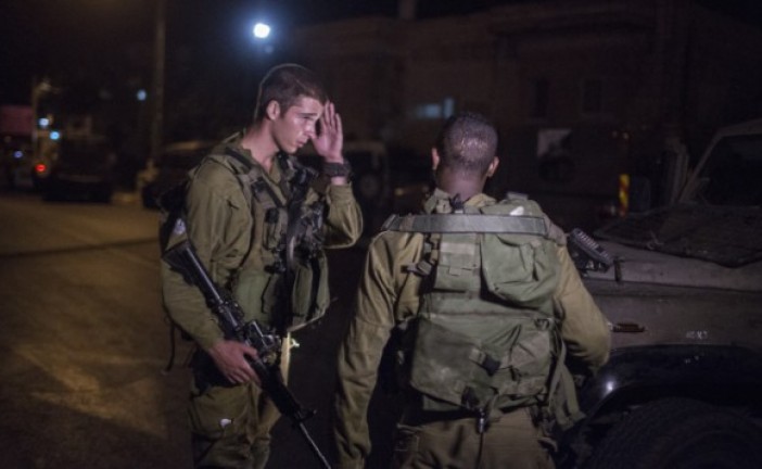 Deux soldats de Tsahal arrêtent un palestinien portant un engin explosif.